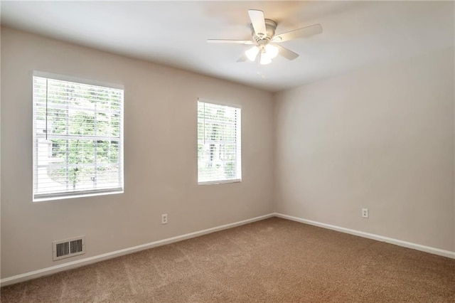 empty room with carpet floors, baseboards, and a ceiling fan