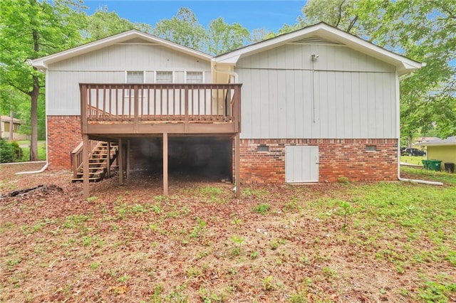back of property with a wooden deck, stairs, and brick siding