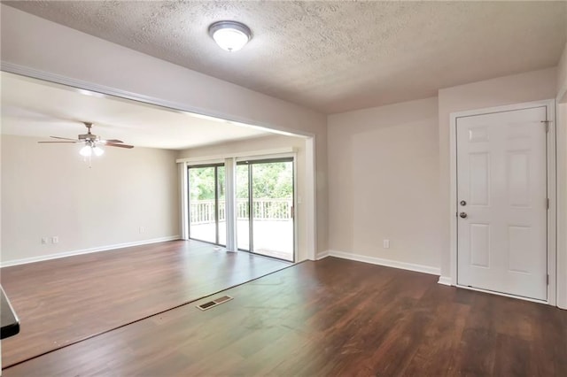 empty room with wood finished floors, a textured ceiling, a ceiling fan, and baseboards