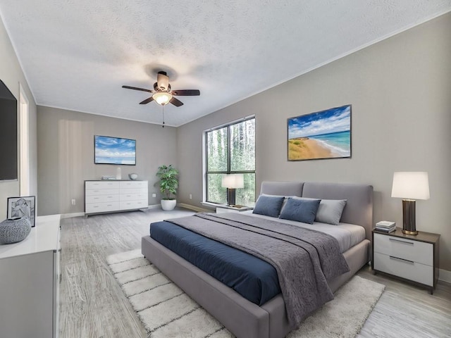 bedroom featuring ceiling fan, light hardwood / wood-style flooring, and a textured ceiling