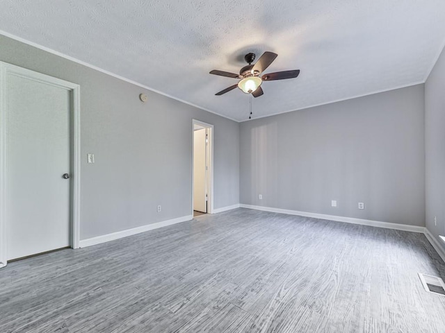 empty room featuring a textured ceiling, hardwood / wood-style flooring, and ceiling fan