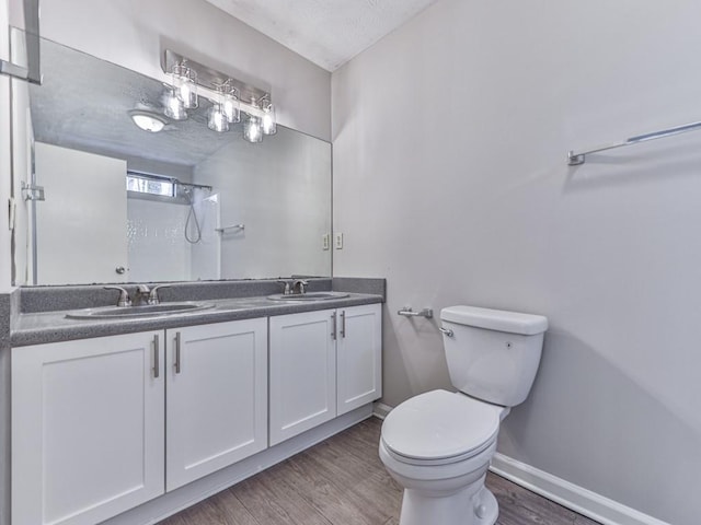 bathroom with walk in shower, vanity, a textured ceiling, hardwood / wood-style floors, and toilet