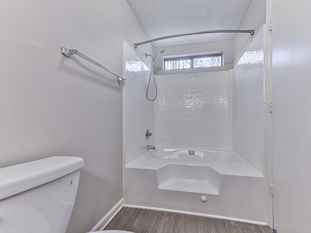 bathroom with hardwood / wood-style floors, a textured ceiling, and toilet