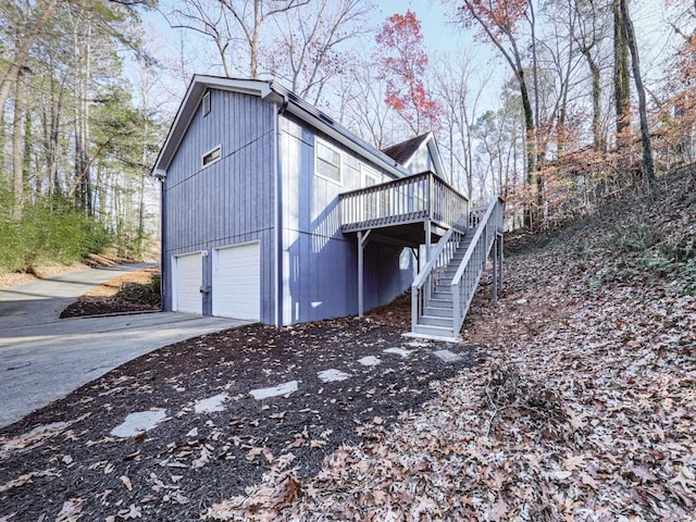 view of property exterior with a garage and a wooden deck