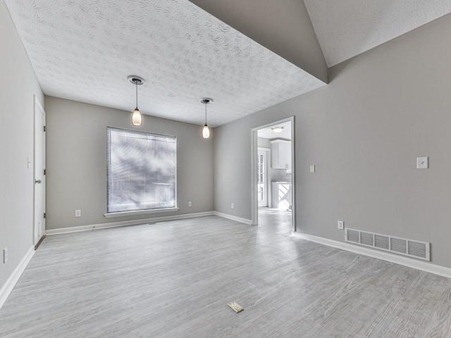 empty room featuring light hardwood / wood-style floors and a textured ceiling