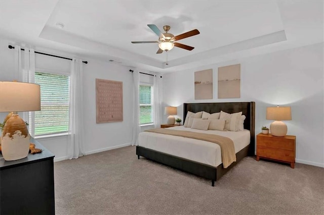 2703 Jordan Ln, Lithia Springs, GA 30122 - bedroom featuring a tray ceiling, light colored carpet, and ceiling fan