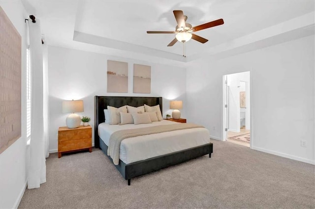 2703 Jordan Ln, Lithia Springs, GA 30122 - bedroom featuring a raised ceiling, carpet flooring, a ceiling fan, and connected bathroom