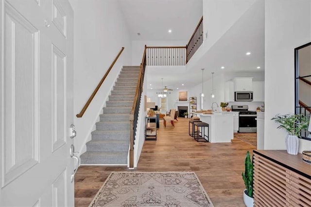 2703 Jordan Ln, Lithia Springs, GA 30122 - foyer entrance featuring stairs, light wood-type flooring, a towering ceiling, a ceiling fan, and recessed lighting