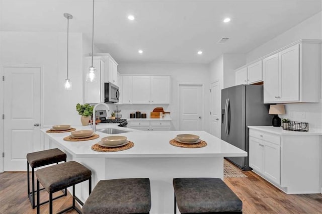 2703 Jordan Ln, Lithia Springs, GA 30122 - kitchen with appliances with stainless steel finishes, a kitchen bar, a peninsula, white cabinetry, and recessed lighting