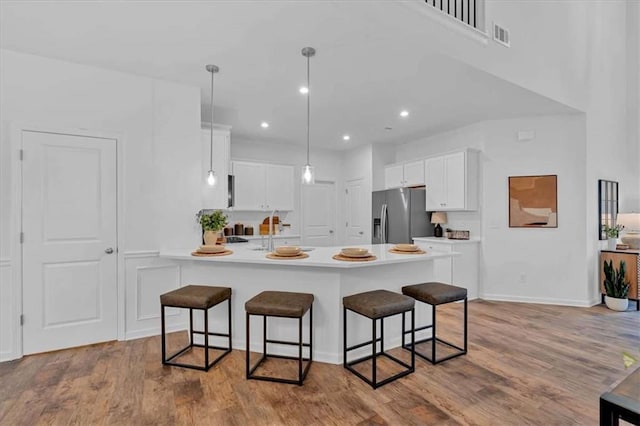 2703 Jordan Ln, Lithia Springs, GA 30122 - kitchen with stainless steel fridge with ice dispenser, a breakfast bar, a peninsula, white cabinets, and recessed lighting