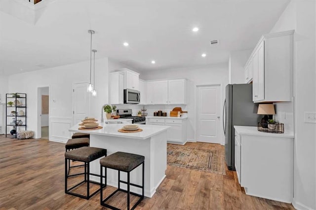 2703 Jordan Ln, Lithia Springs, GA 30122 - kitchen featuring stainless steel appliances, a breakfast bar area, light countertops, white cabinetry, and wood finished floors