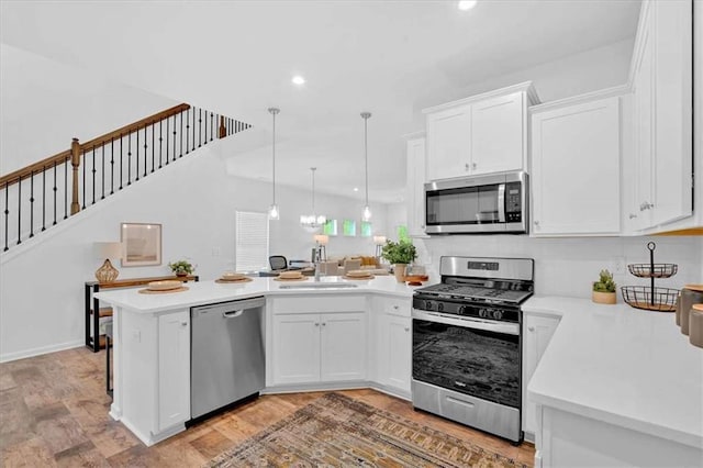 2703 Jordan Ln, Lithia Springs, GA 30122 - kitchen with appliances with stainless steel finishes, a peninsula, light countertops, white cabinets, and recessed lighting