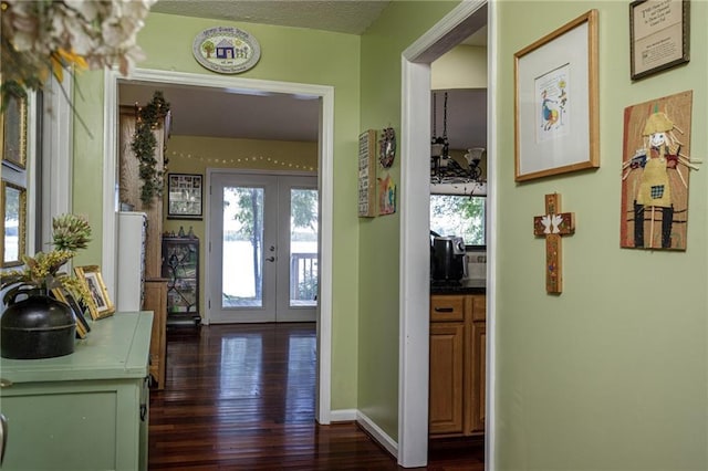 entryway featuring french doors, dark wood finished floors, and baseboards