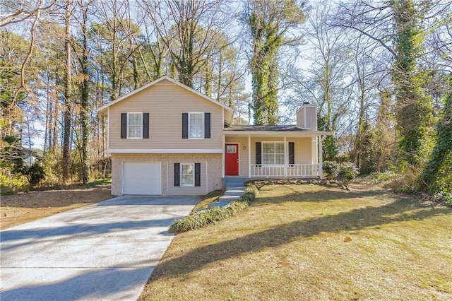 tri-level home featuring a garage, a front yard, and covered porch