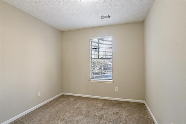 empty room featuring a textured ceiling and light carpet