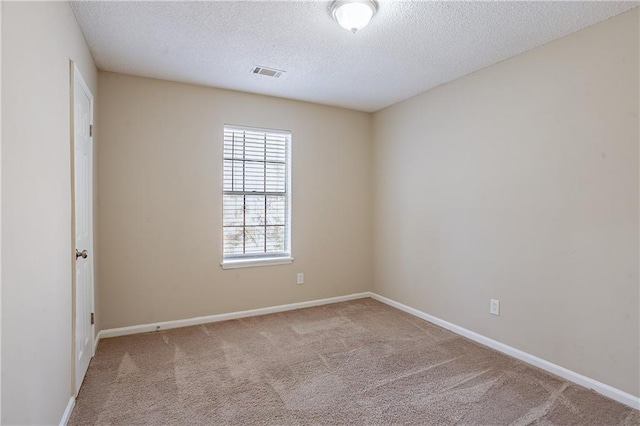 carpeted empty room with a textured ceiling