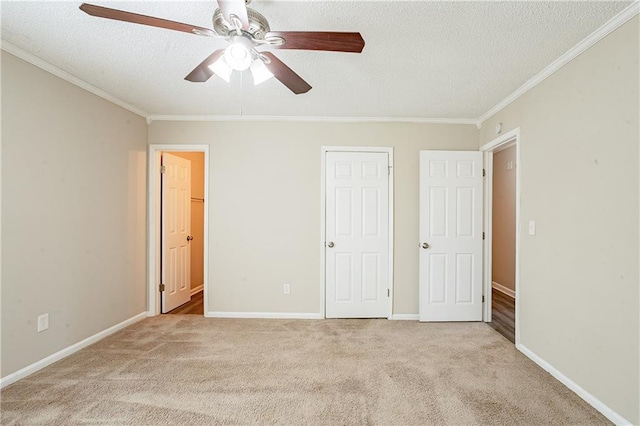 unfurnished bedroom with ornamental molding, ceiling fan, light colored carpet, and a textured ceiling