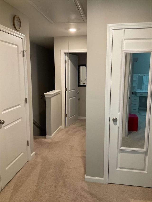 hallway featuring light colored carpet