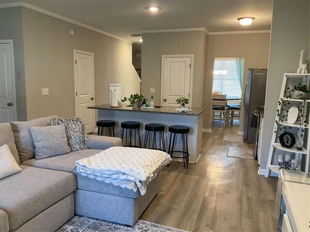 living room featuring wood-type flooring and ornamental molding