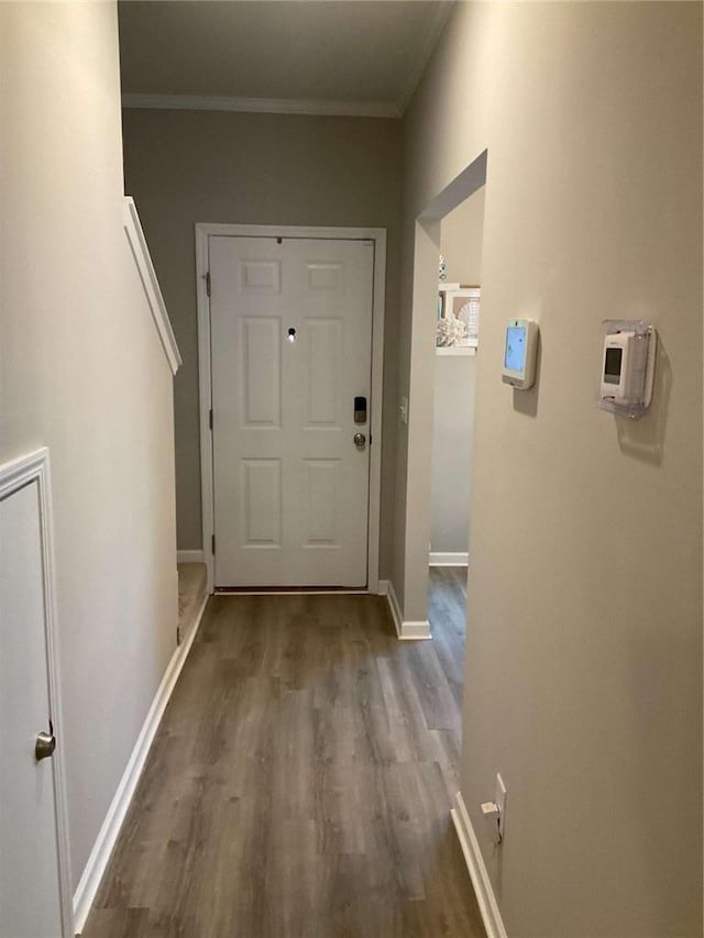 doorway with hardwood / wood-style floors and ornamental molding