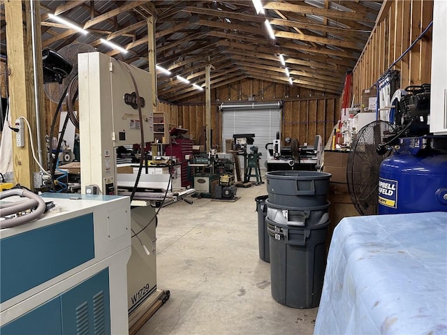 interior space featuring concrete flooring, vaulted ceiling, and a workshop area