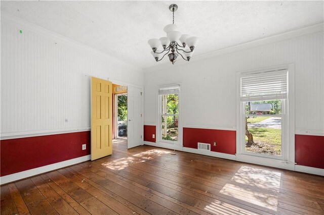 6048 Kings Mountain Way, Tucker, GA 30087 - spare room featuring baseboards, an inviting chandelier, crown molding, visible vents, and hardwood / wood-style flooring