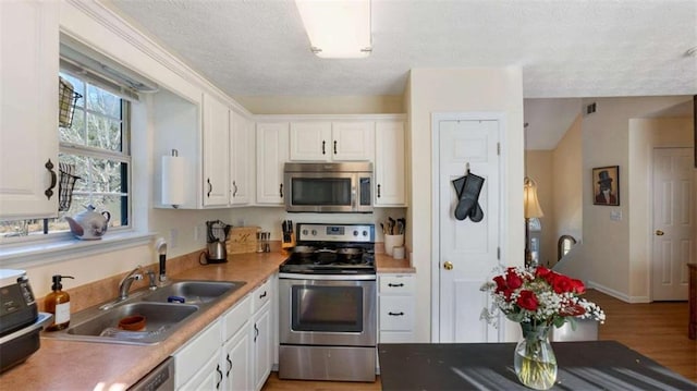 kitchen featuring a sink, visible vents, appliances with stainless steel finishes, and white cabinets