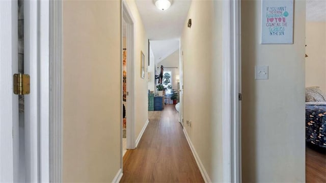 hall featuring baseboards and wood finished floors