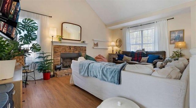 living room featuring a fireplace, vaulted ceiling, and wood finished floors