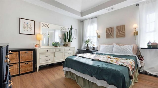 bedroom with visible vents and wood finished floors