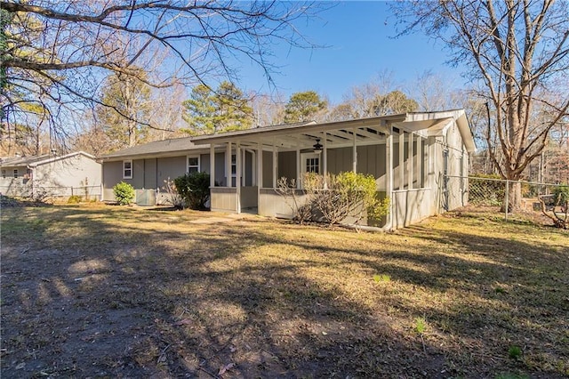 rear view of house featuring a yard, central AC unit, ceiling fan, and a sunroom