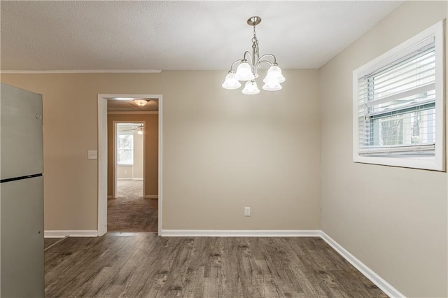 empty room featuring a chandelier, dark hardwood / wood-style flooring, and plenty of natural light