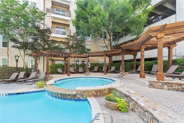 view of pool featuring a community hot tub, a patio area, and a pergola