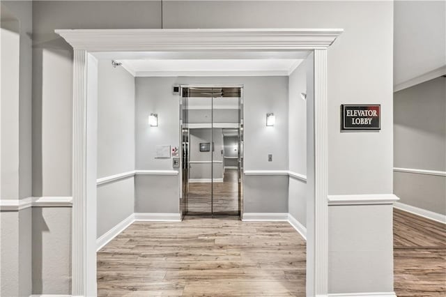 interior space with ornamental molding and light wood-type flooring