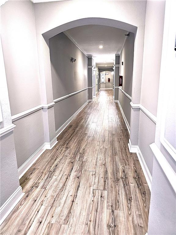 hall featuring hardwood / wood-style flooring and crown molding