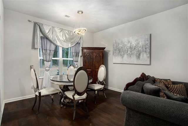 dining room featuring dark hardwood / wood-style flooring and a notable chandelier