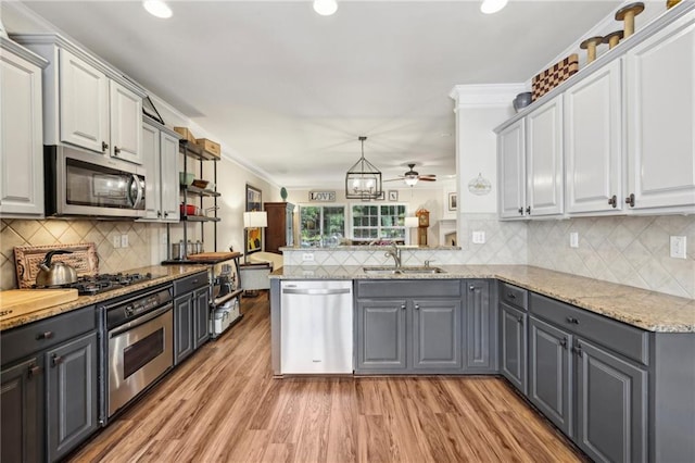 kitchen with stainless steel appliances, gray cabinets, decorative backsplash, and kitchen peninsula