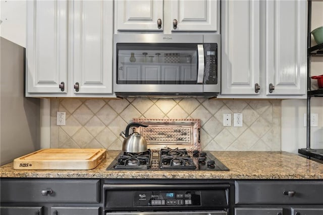 kitchen with backsplash, appliances with stainless steel finishes, and white cabinets