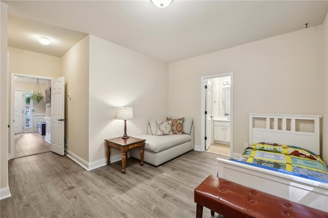 bedroom featuring ensuite bath and light hardwood / wood-style flooring