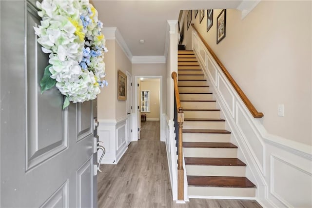 entrance foyer featuring light wood-type flooring and crown molding