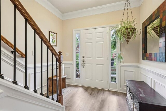 entrance foyer featuring ornamental molding, hardwood / wood-style floors, and a healthy amount of sunlight