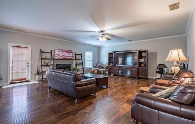 living room with a fireplace, visible vents, ceiling fan, wood finished floors, and baseboards