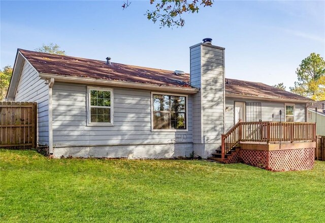 rear view of property featuring a lawn and a wooden deck