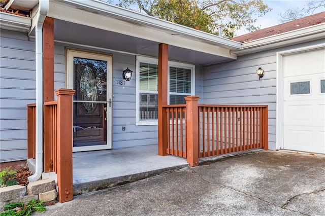 property entrance featuring covered porch and a garage