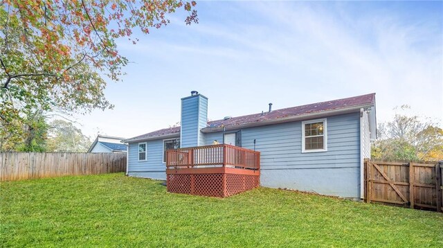 back of house with a lawn and a deck