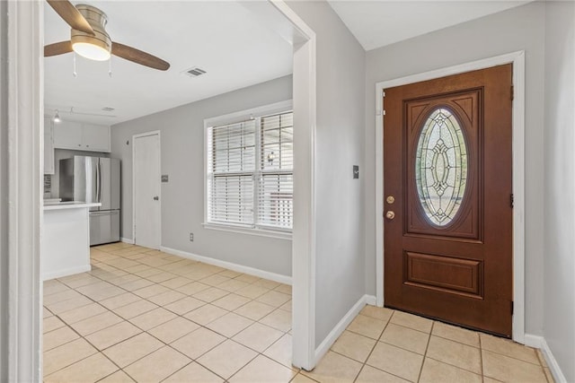 foyer entrance with ceiling fan and light tile patterned floors