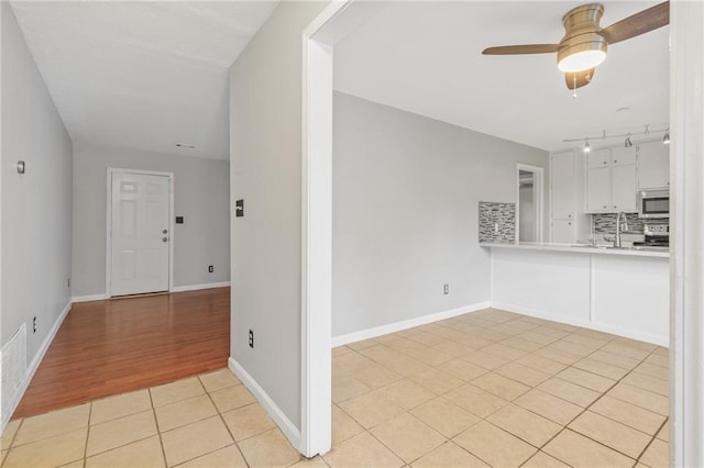 interior space featuring ceiling fan, light wood-type flooring, and sink