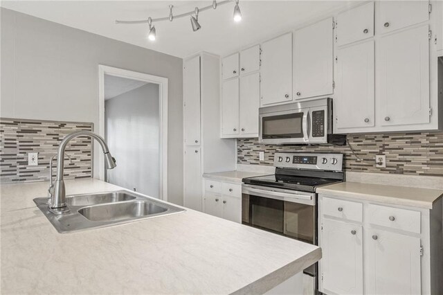 kitchen featuring backsplash, sink, white cabinetry, and stainless steel appliances