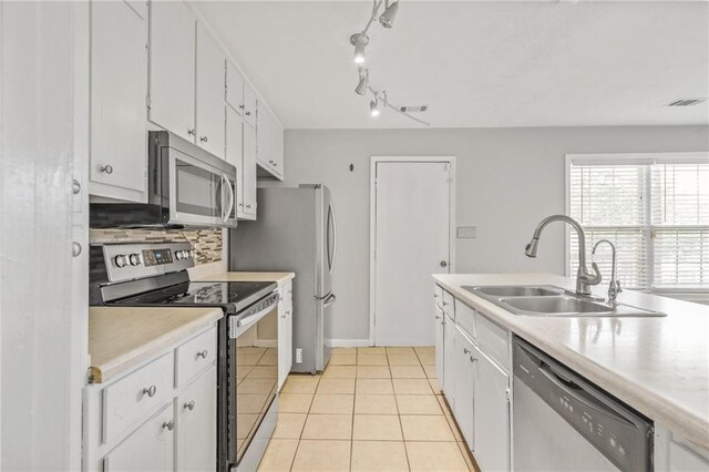 kitchen with white cabinets, sink, light tile patterned floors, and stainless steel appliances