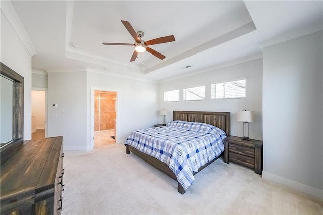 bedroom featuring light carpet, baseboards, a tray ceiling, and crown molding